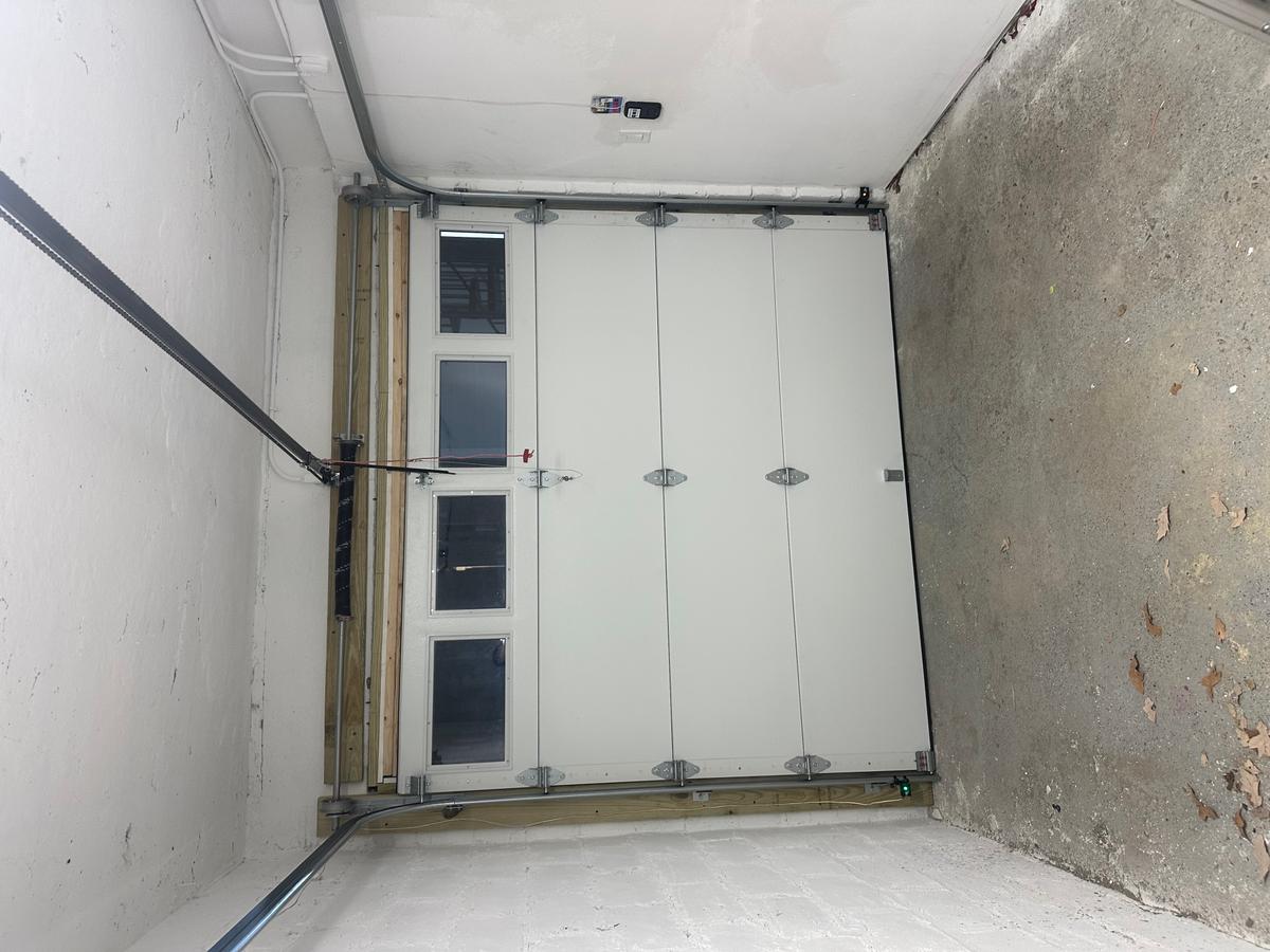 Interior view of insulated white sectional door with vertical window inserts — MA install