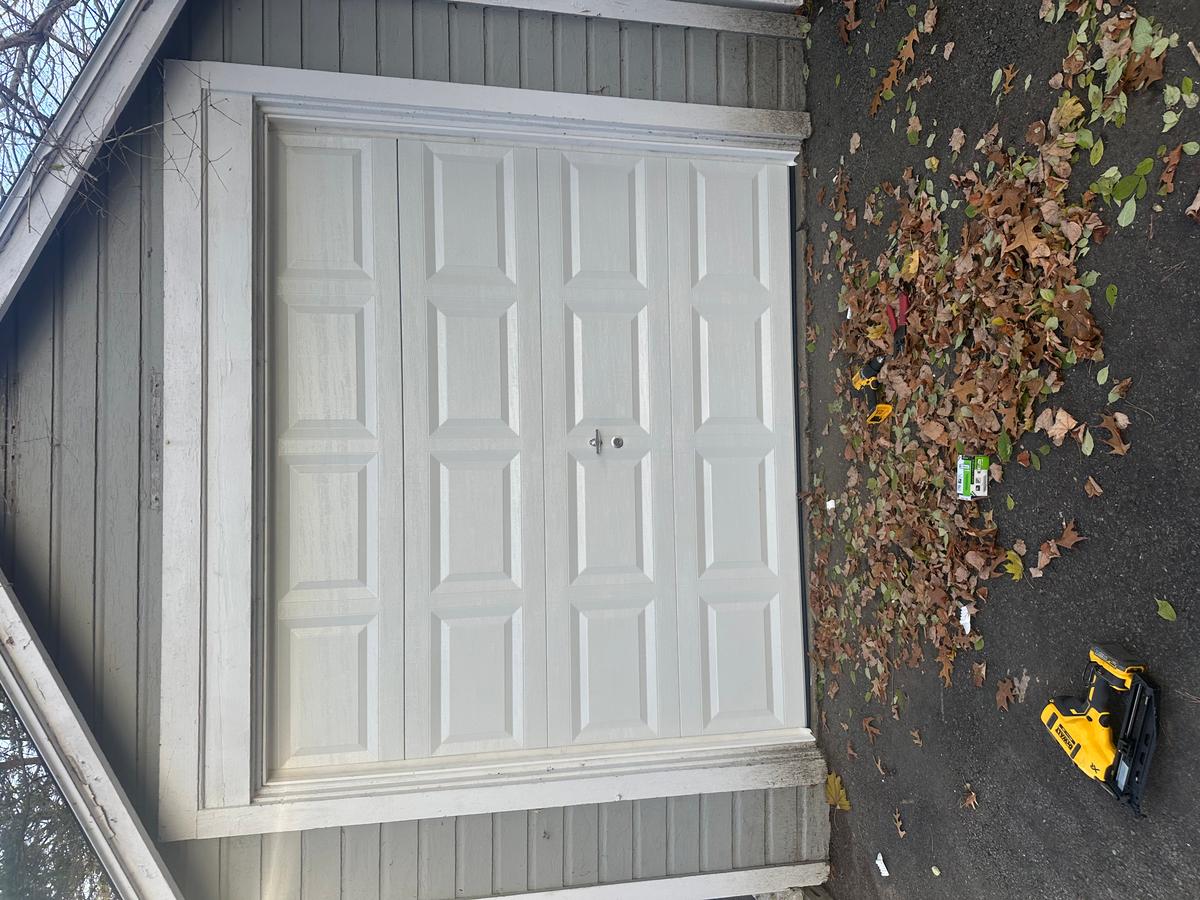 White raised-panel single garage door installed on detached garage in Massachusetts